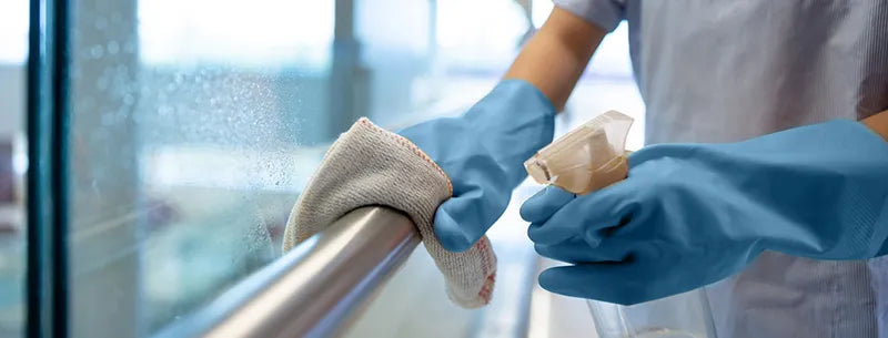 Healthcare staff following proper cleaning protocols on antimicrobial-coated surfaces.