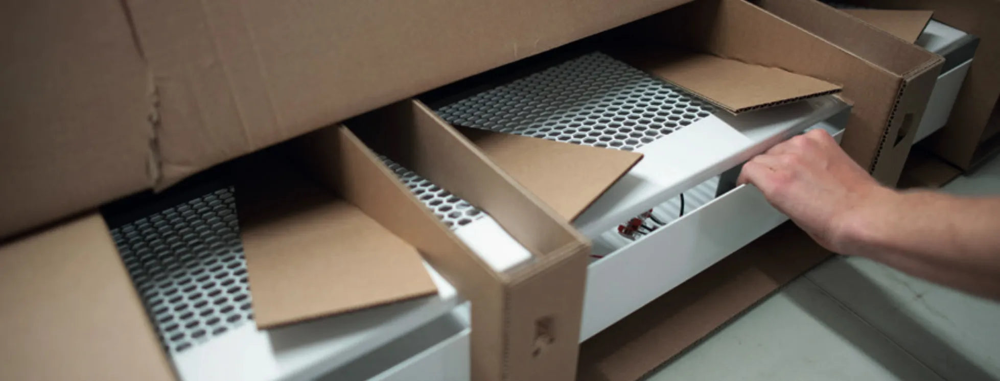 A technician unboxing ASEPT-1X MAX™ disinfection units, preparing for certified commissioning and performance verification.
